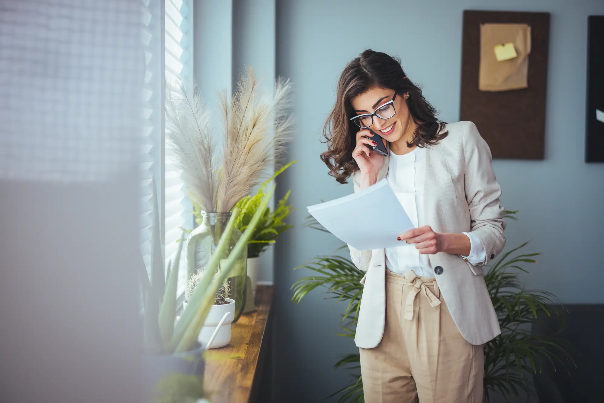 Real estate support person on phone looking at file in office